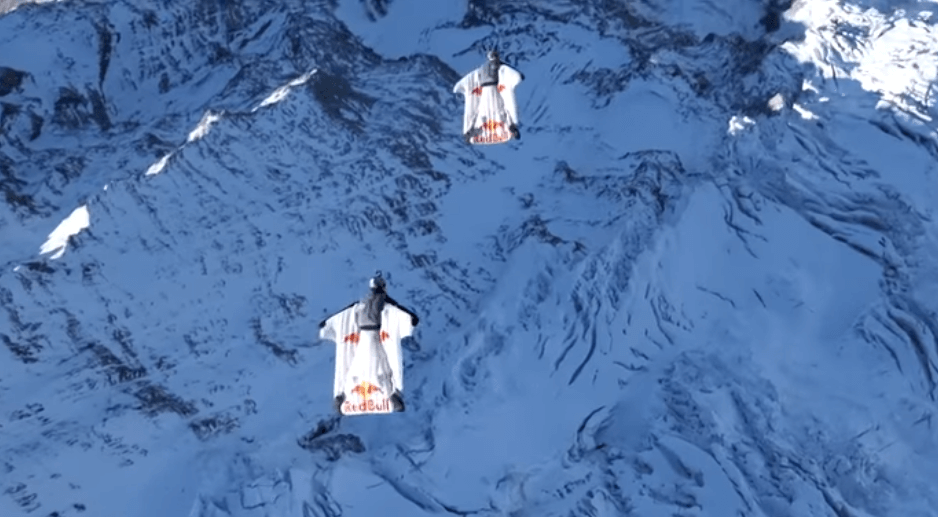 VIDEO: Two wingsuit flyers jump from top of mountain into a flying plane