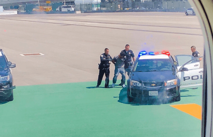Man arrested at LAX after jumping fence and doing push-ups on runway