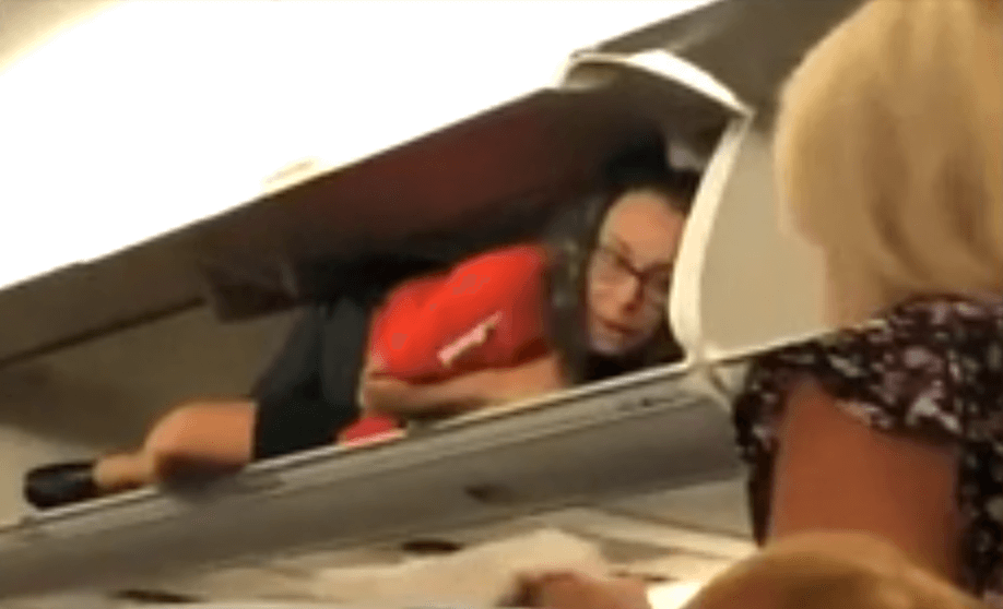 Strange moment a Southwest flight attendant greets passengers from inside an overhead locker