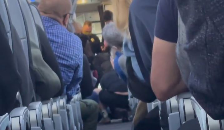 American flight attendant hits passenger over the head with coffee pot as he tries to open plane door